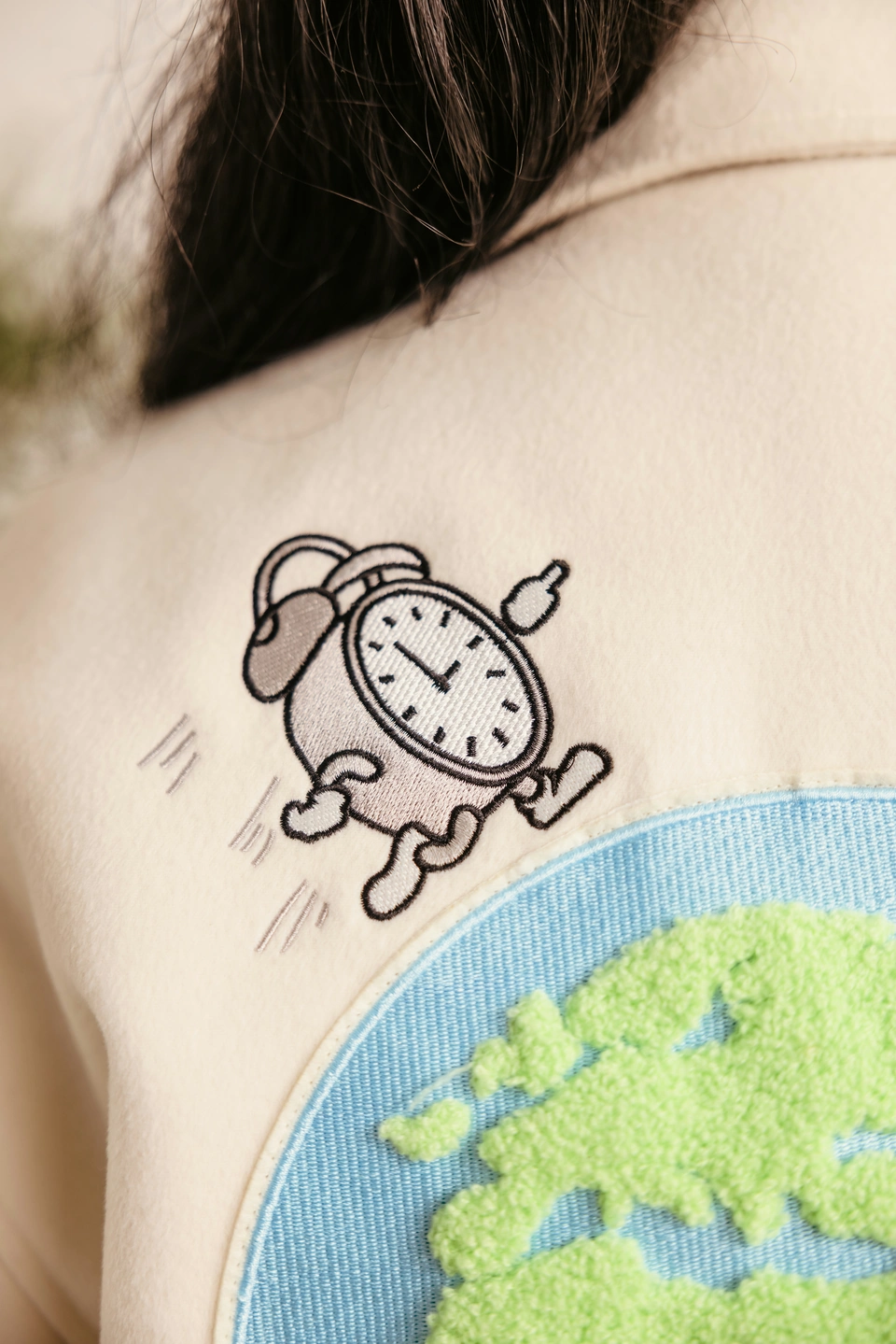 Beige Globe Varsity Jacket — embroidered globe and clock detail on the back