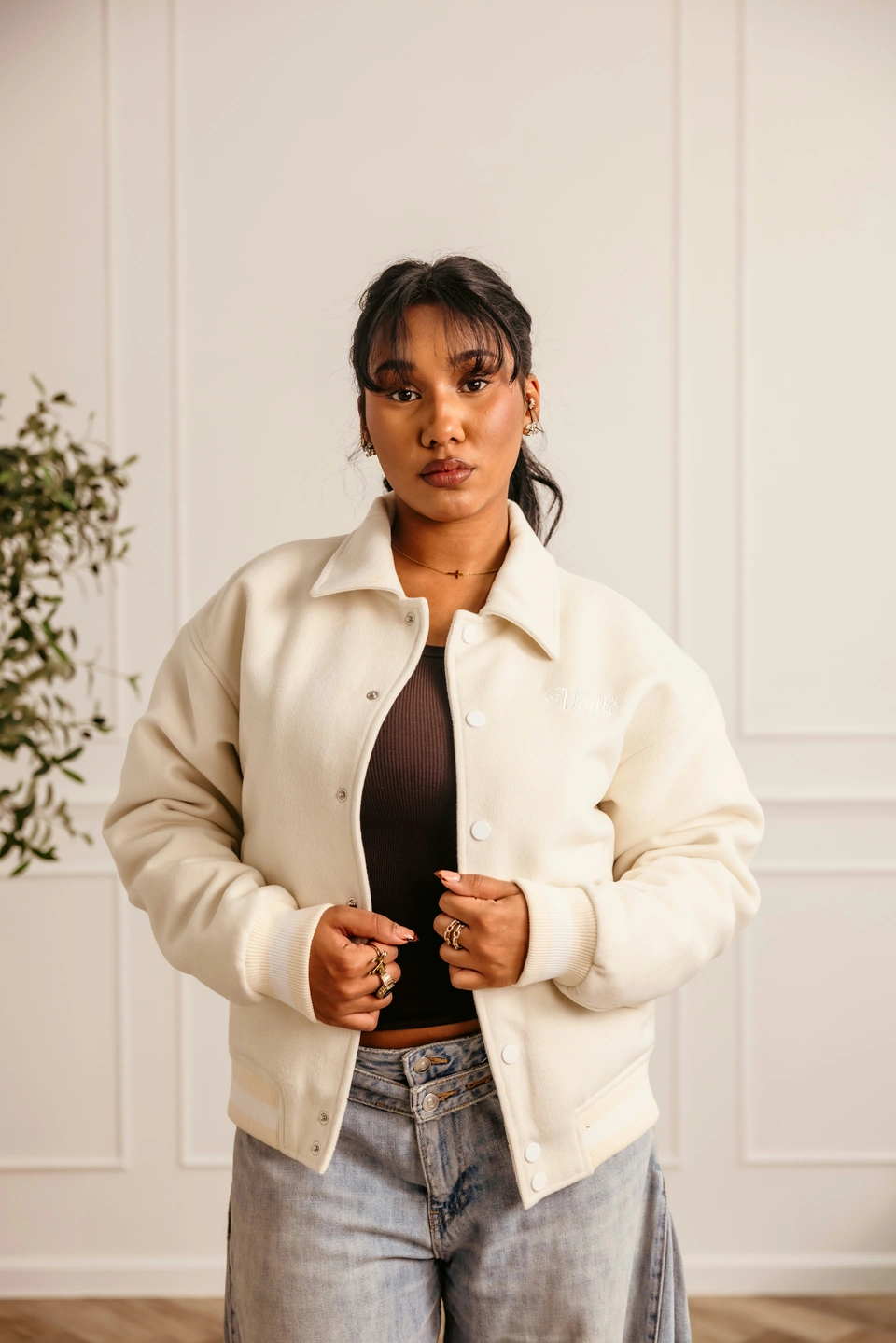 Beige Globe Varsity Jacket — female model, upper-body front view