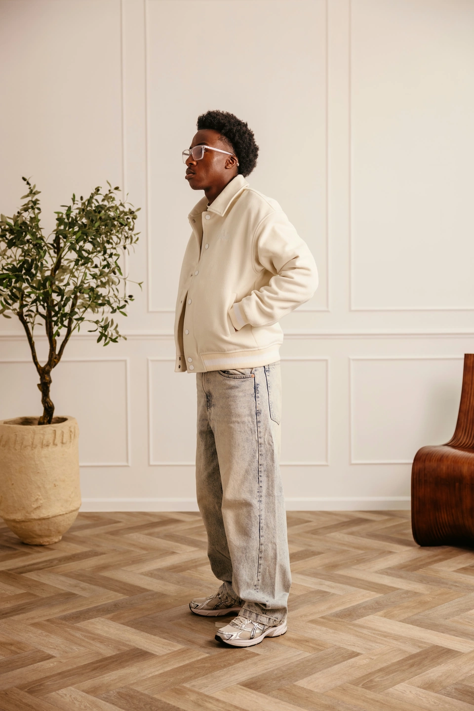 Beige Globe Varsity Jacket — male model, full-length side view